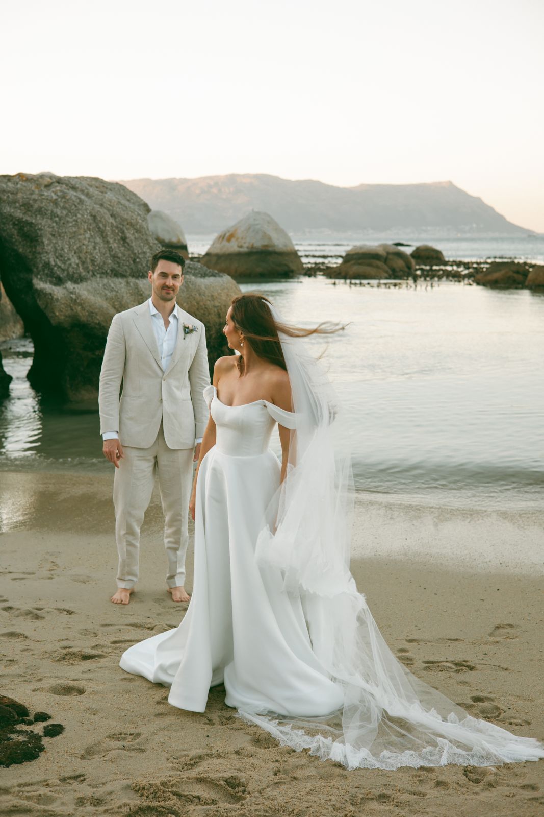 Couple on the sand at a Cape beach with mountains behind