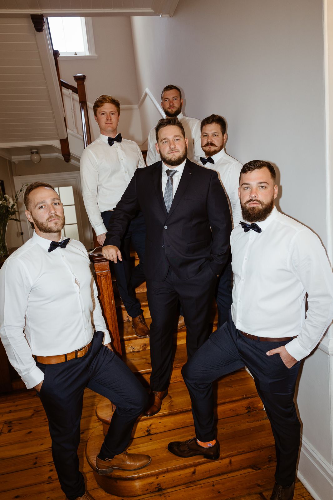 Groom and groomsmen on a wooden staircase