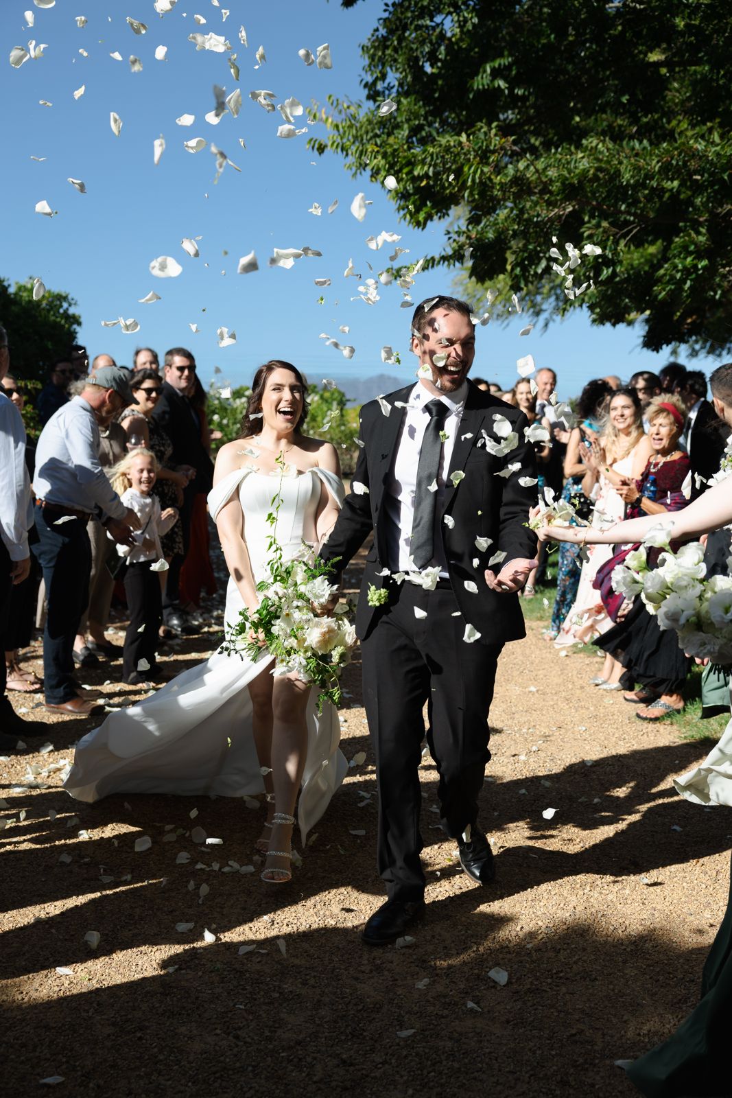 Couple walking back down the aisle through confetti