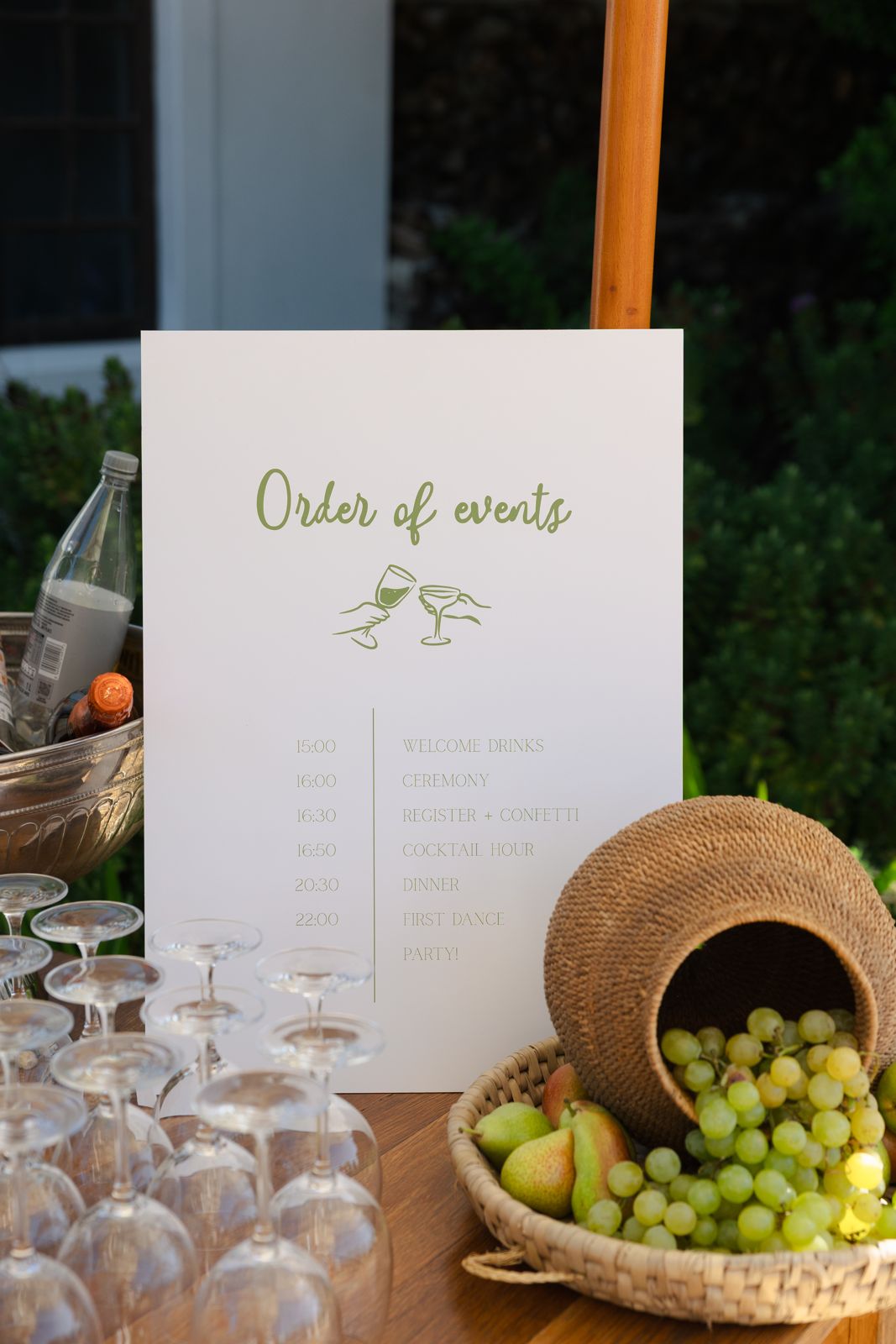 Order of events sign with fruit and glassware