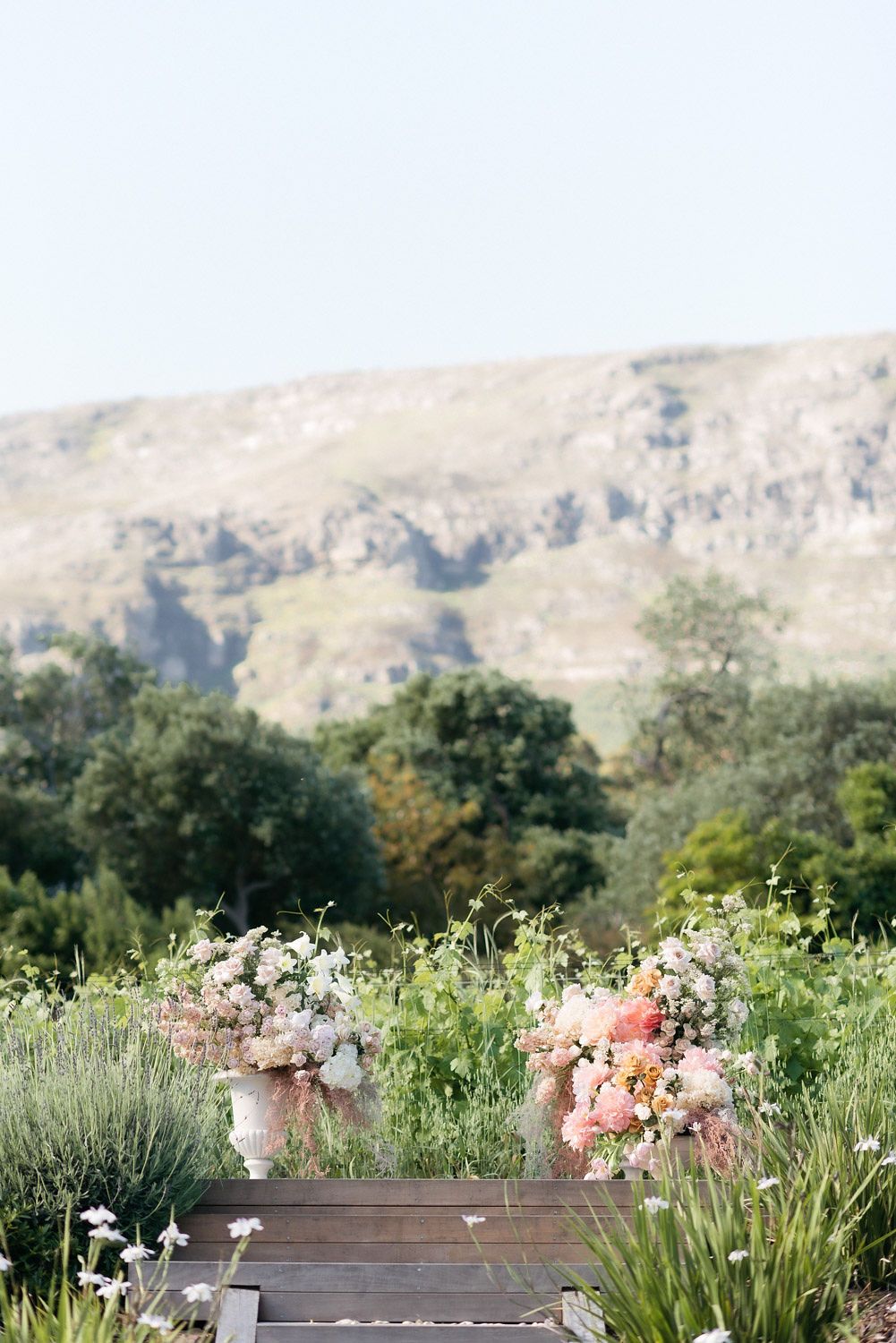 Ceremony florals in urns with the mountain behind