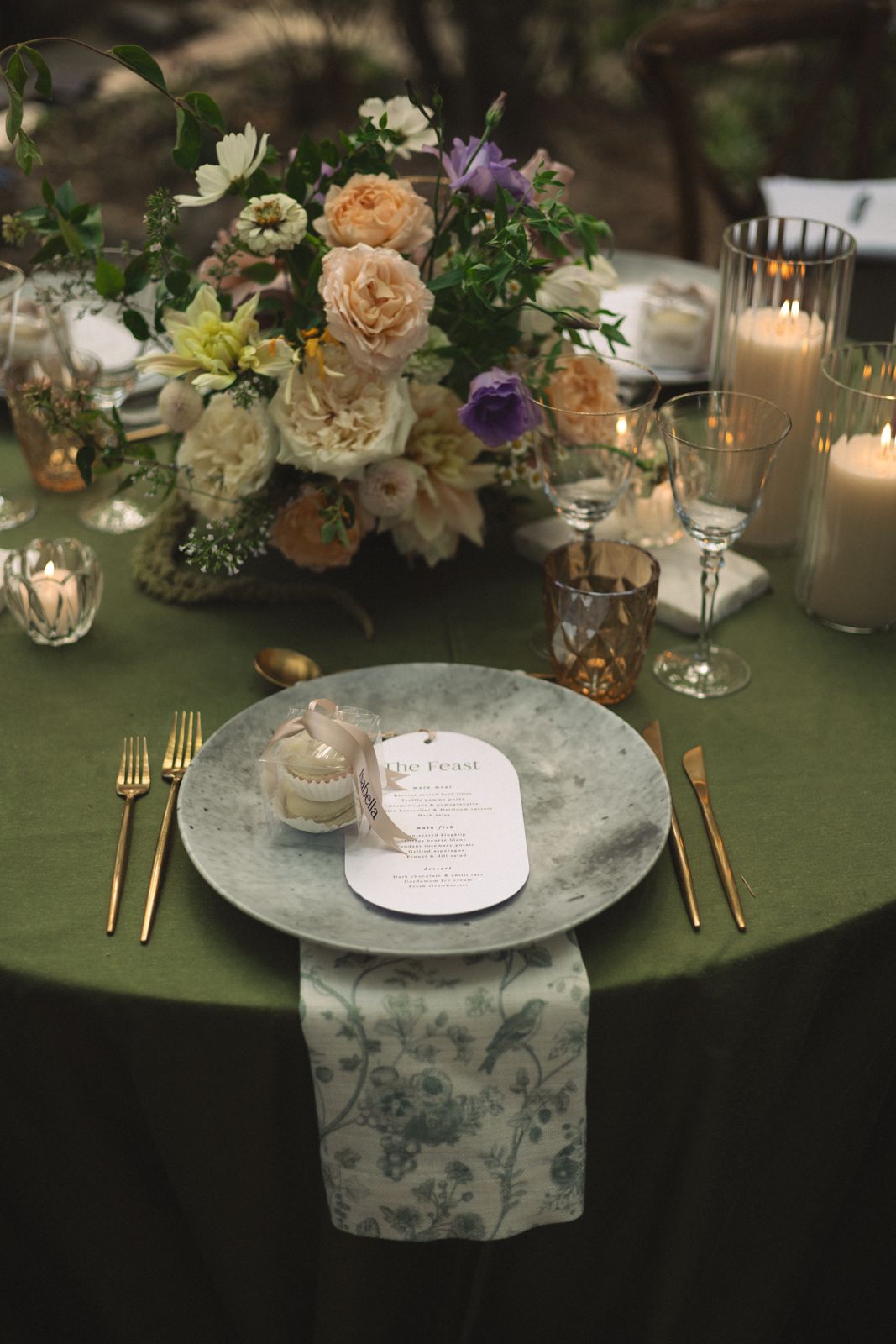 Place setting on a green tablecloth with peach and lilac florals