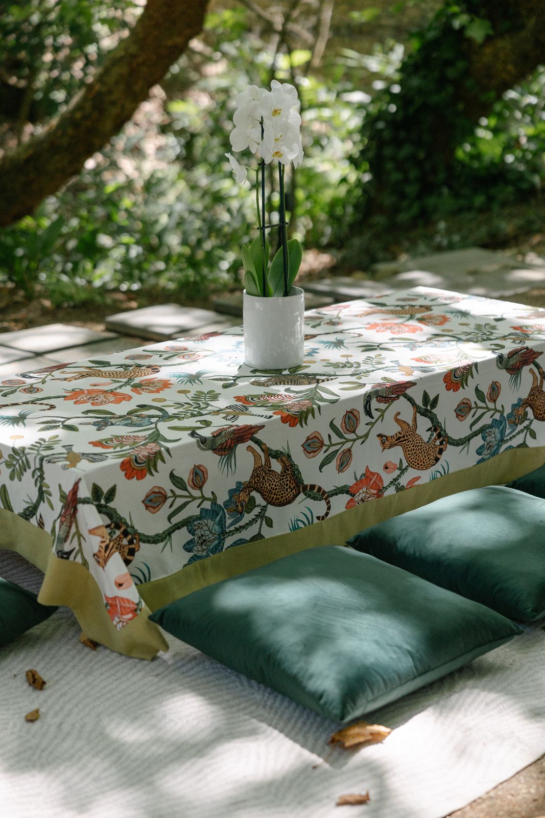 Low table with patterned cloth, orchid and velvet cushions