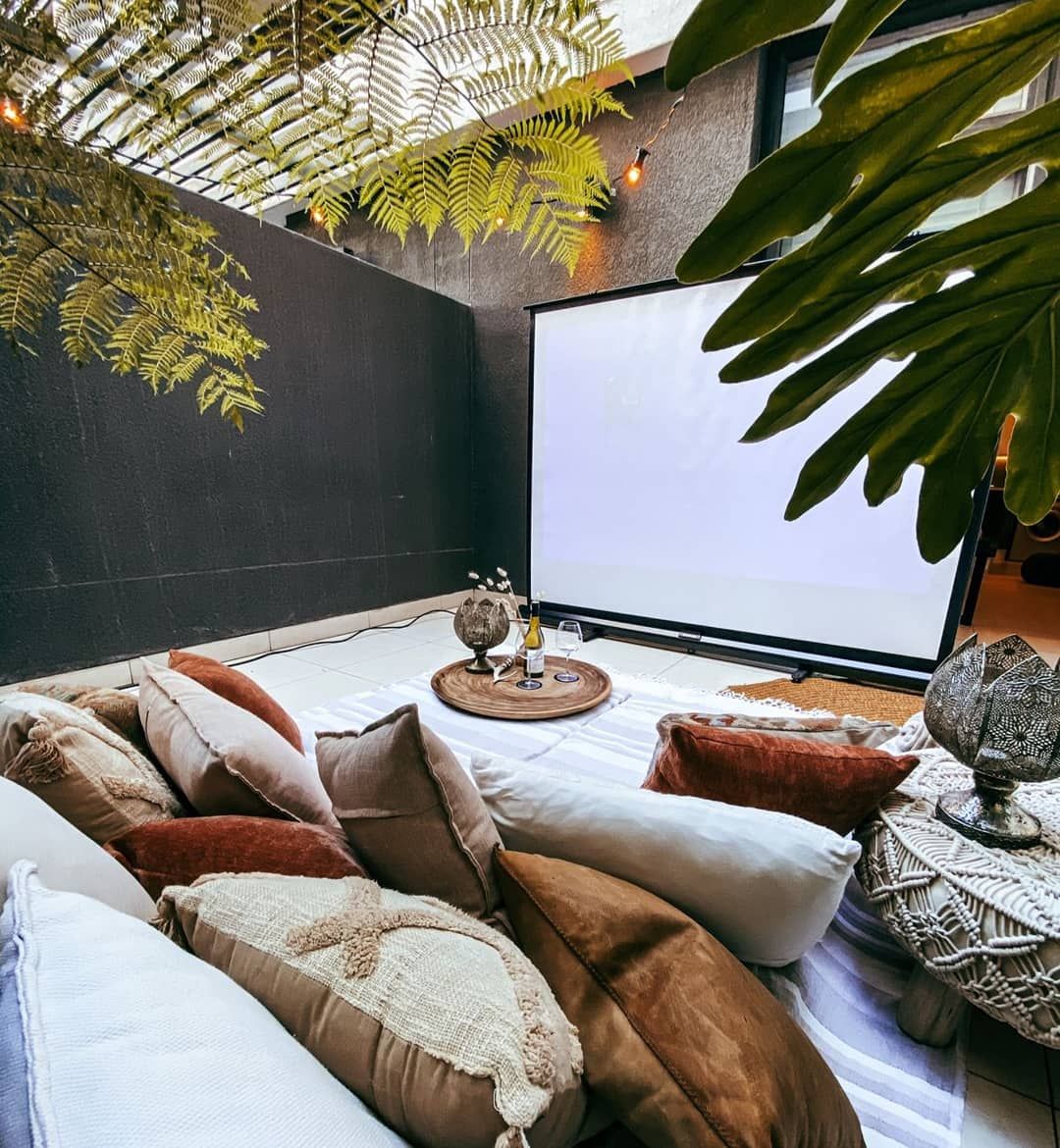 Cosy courtyard cinema with cushions under the ferns