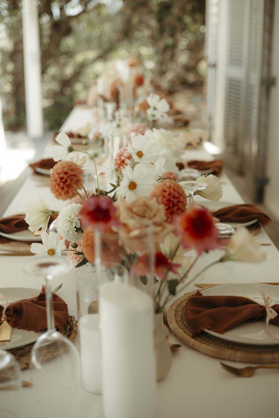 Long table with dahlias, cosmos and rust linen napkins
