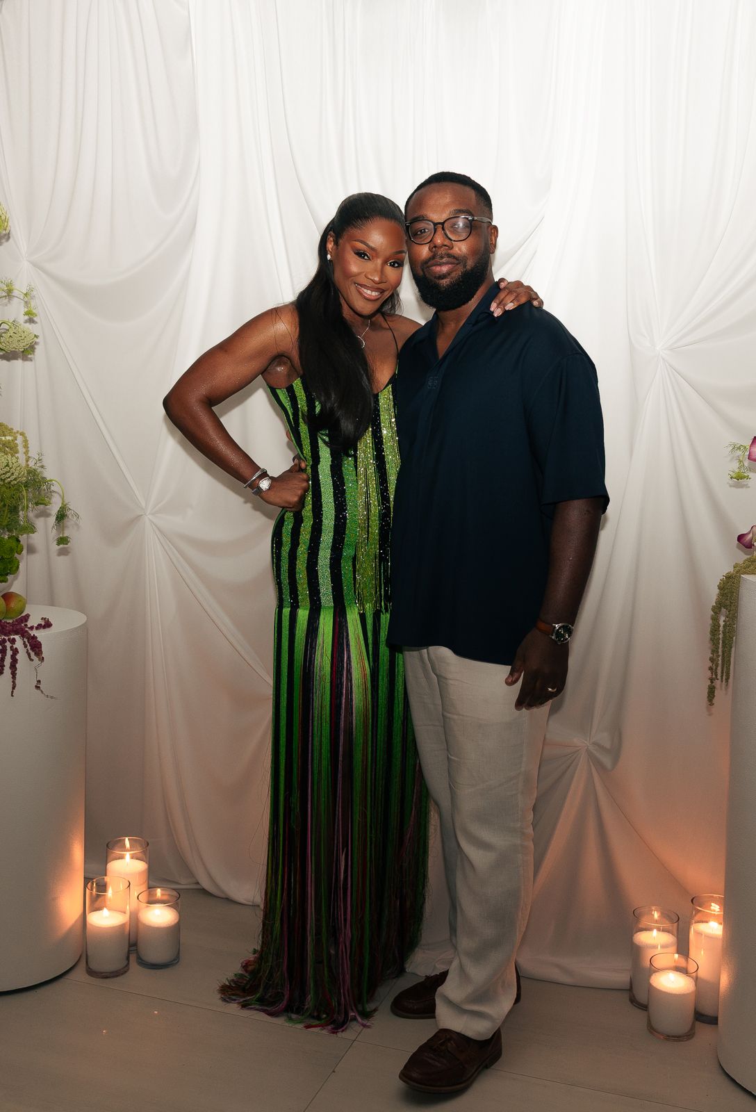 Couple in front of a white draped backdrop with candles