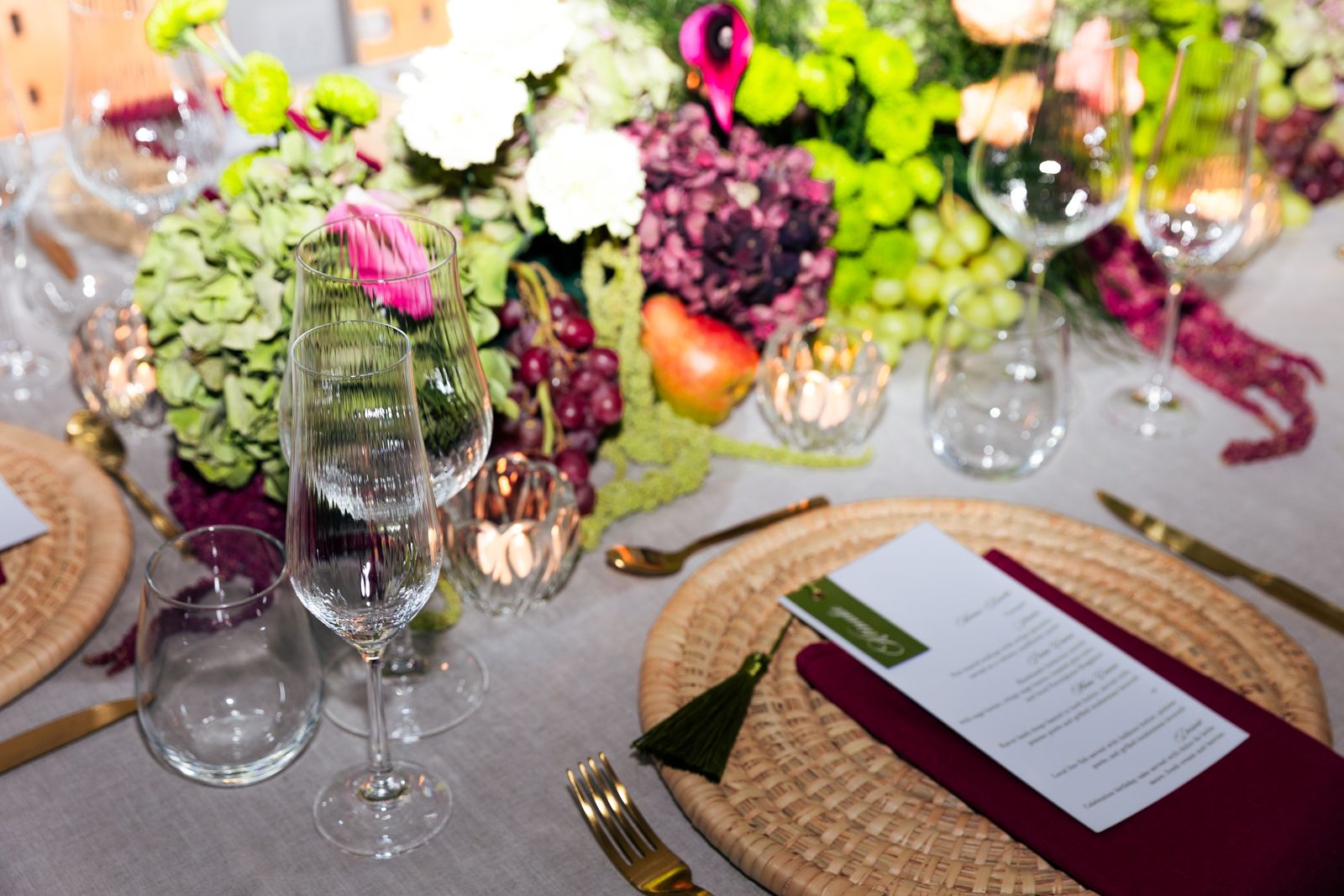 Place setting with menu, tassel and a fruit and flower centrepiece