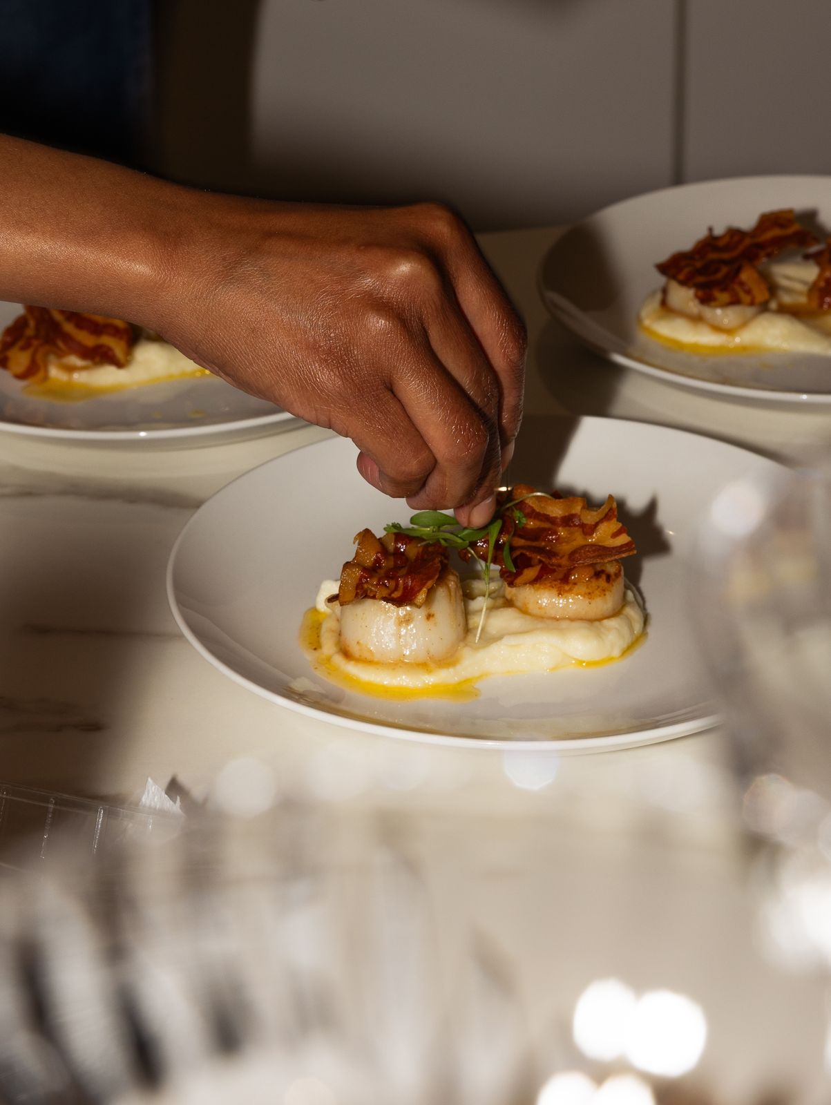 Chef plating seared scallops