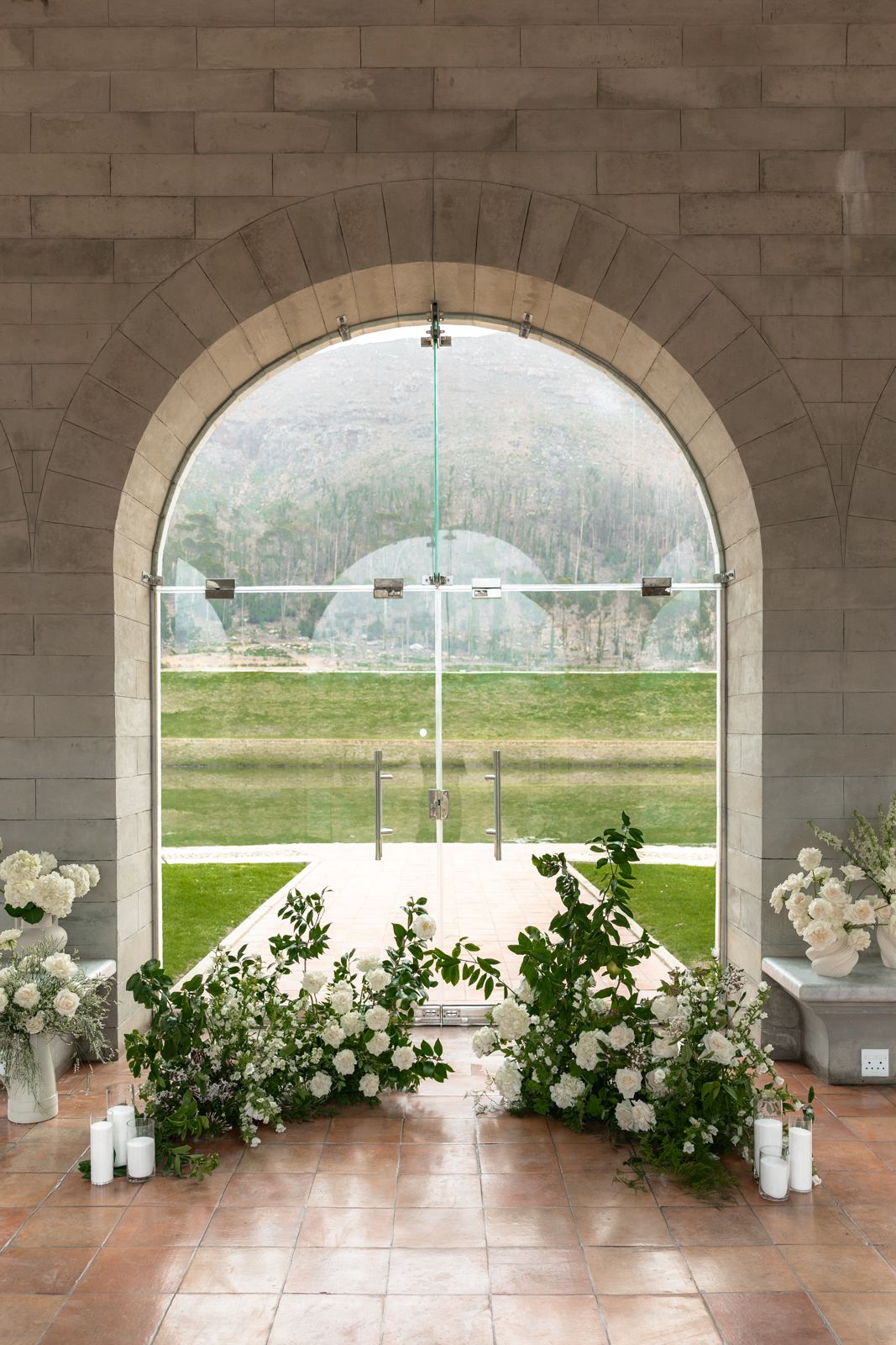 Arched doorway framed with white florals and candles