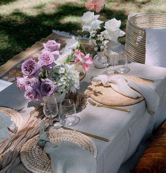 Low picnic table with lilac florals, woven placemats and cushions
